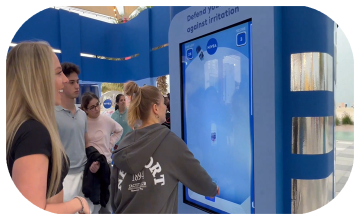 Guests playing the interactive Catch and Dodge game at a Niveae event in Dubai. Custom branded screen with data capture for exhibition marketing